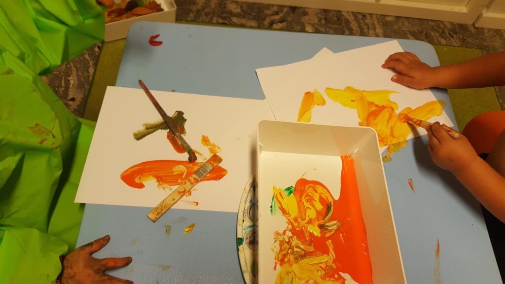 Barn som målar i orange på Vallare Öppna förskola