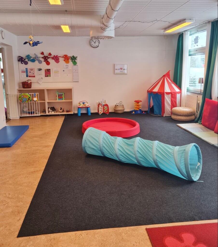 En lektunnel i turkost på lekmatta